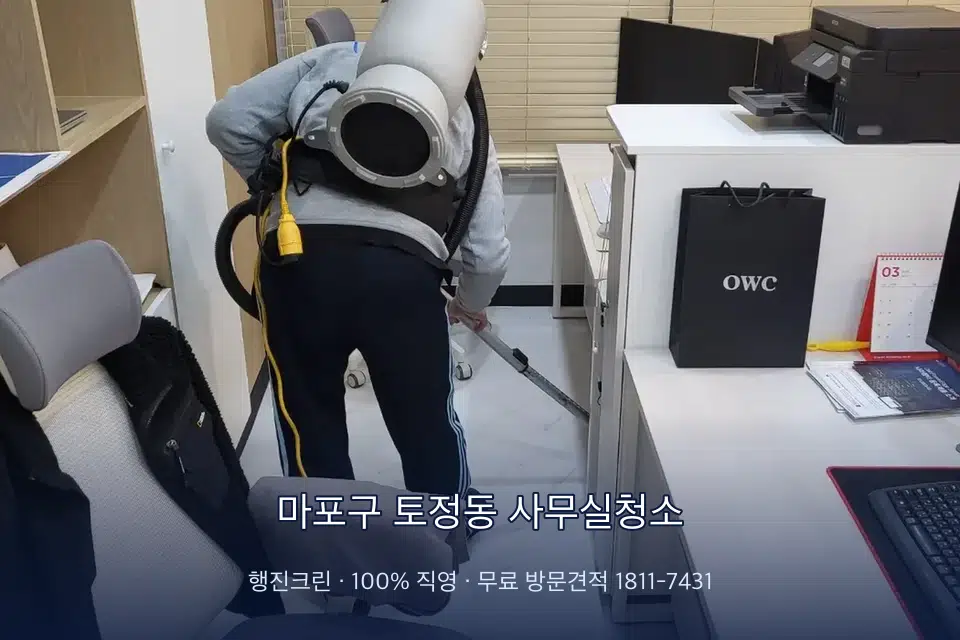 마포구 토정동 사무실청소 사무실 바닥을 진공 청소하는 작업자